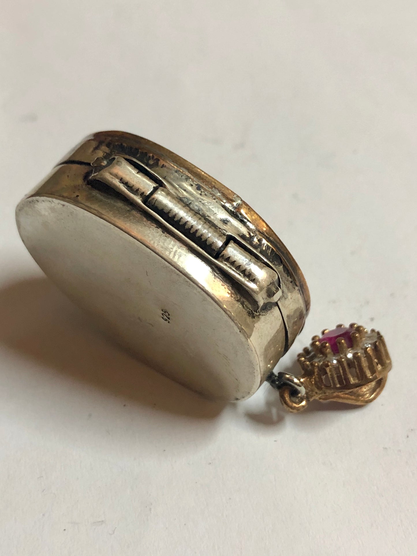 A 925 Silver Pendant with Sapphire stones, it does open and close as a box.