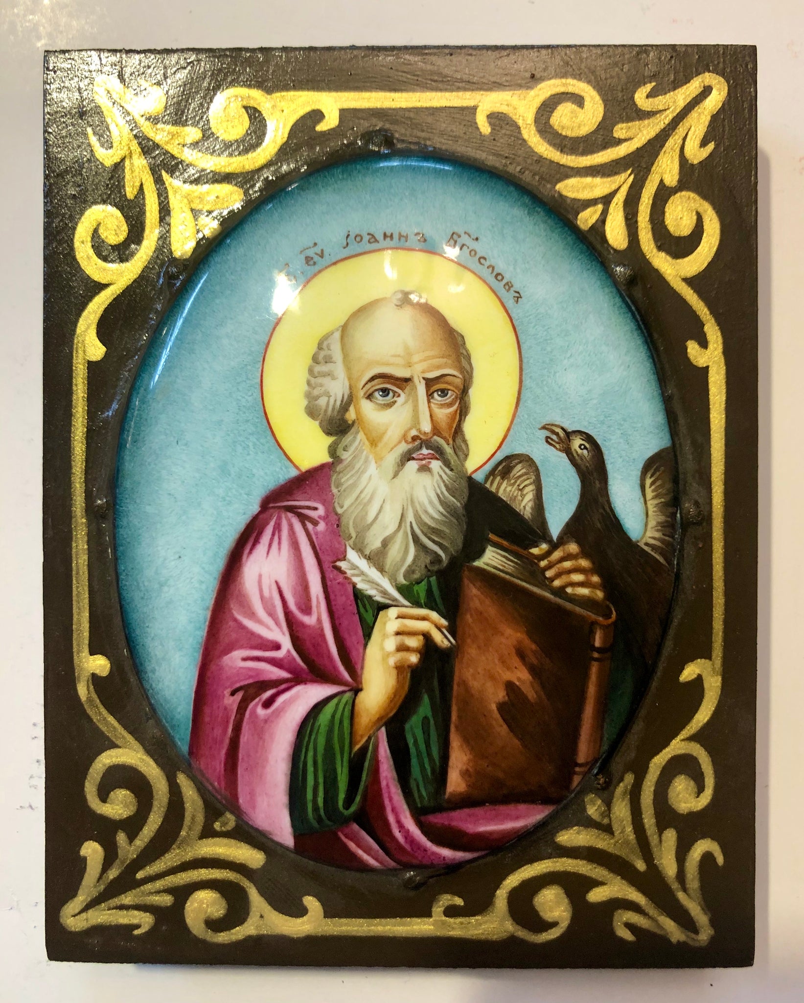 A Russian Enameled icon of St. John The Evangelist, wood carved.