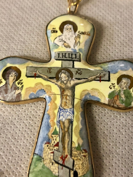 A porcelain Cross, depicting Jesus’s crucifixion. 14K gold.