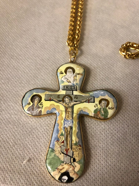 A porcelain Cross, depicting Jesus’s crucifixion. 14K gold.