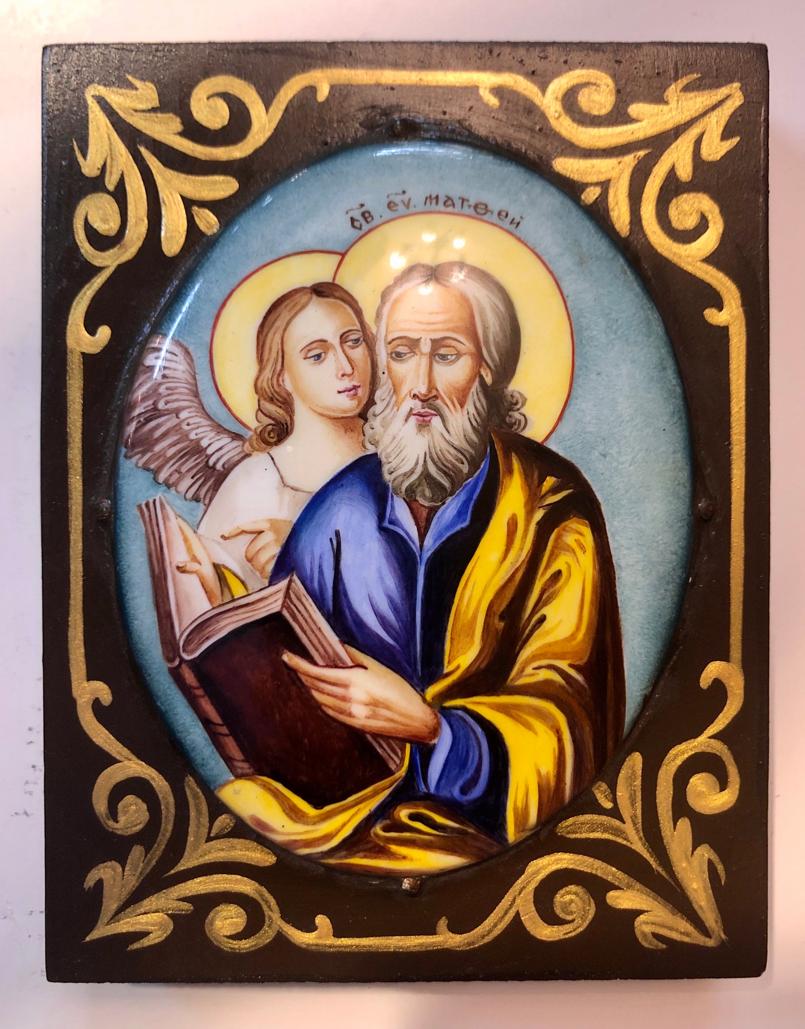 A Russian Enameled icon of St. Mathew The Evangelist, wood carved. 20th Century.