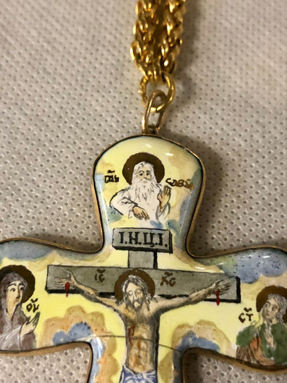 A porcelain Cross, depicting Jesus’s crucifixion. 14K gold.