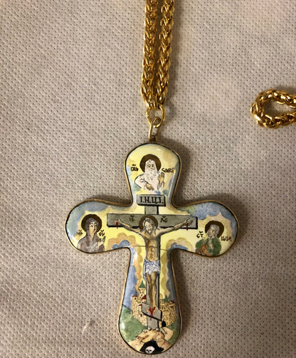 A porcelain Cross, depicting Jesus’s crucifixion. 14K gold.